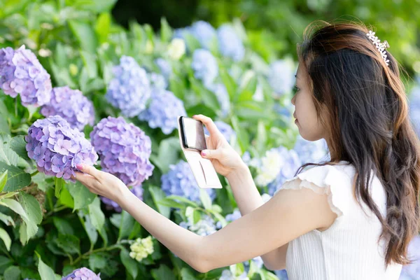 Akıllı telefonlu ortanca fotoğrafı çeken bir kadın.