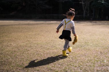 little asian girl with teddy bear  in park.