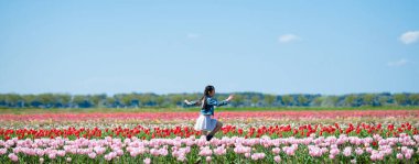Tarlada güzel çiçekleri olan küçük tatlı Asyalı kız.