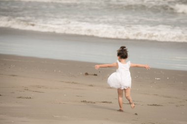 Kumsalda oynayan kız.