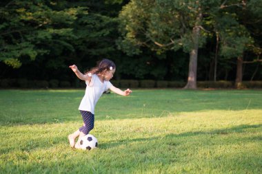 Parkta top oynayan kız.