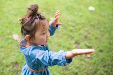 Çimenlerde oynayan kız