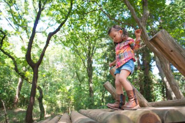 Parkın ormanında oynayan kız.