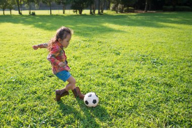 Kız futbol topuyla oynuyor.