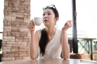 young asian woman  drinking coffee in a cafe