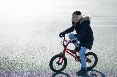 Dışarıda bisiklet süren genç bir kadın.