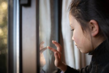 Kız pencereden dışarı bakıyor.