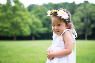 Çiçek saçı takan bir kız.