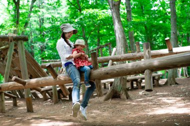 Anne ve kızı orman parkında oynuyor.