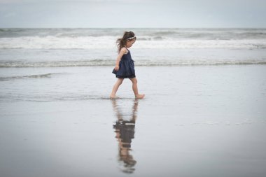 Kumsalda oynayan kız.