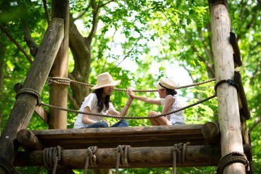 Anne ve kızı orman parkında oynuyorlar.