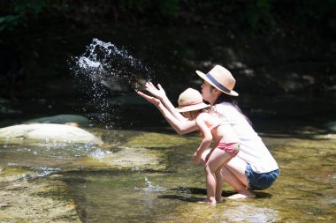 kadın ve genç kız suda oynuyorlar.