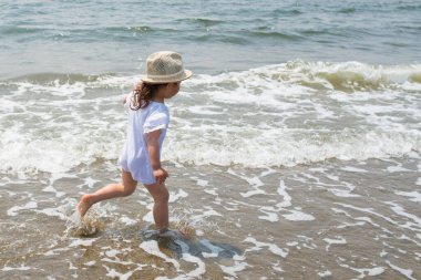 Kumsalda yürüyen küçük kız