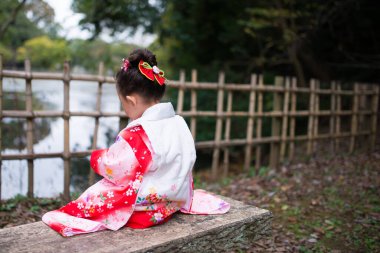 Park 'ta geleneksel Japon kimonolu küçük bir kız. 