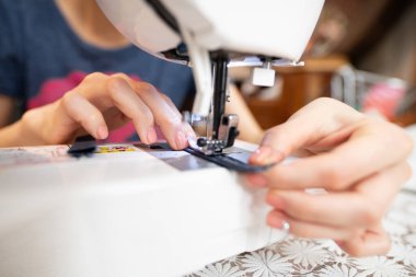 Dikiş makinesi kullanan kadınların elleri.