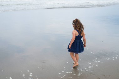 Kumsalda oynayan kız. 