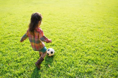 Kız futbol oynuyor.