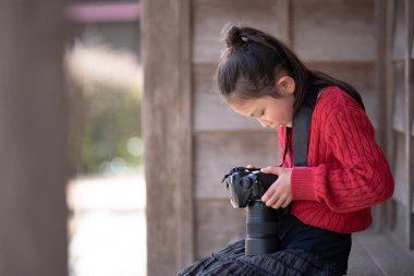 Tek lensli refleks kamerayla fotoğraf çeken bir kız.