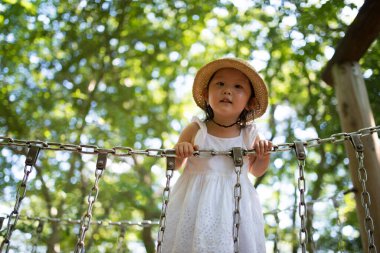 Ormandaki parkta oynayan kız.