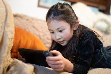 Kanepede oyun oynayan kız.