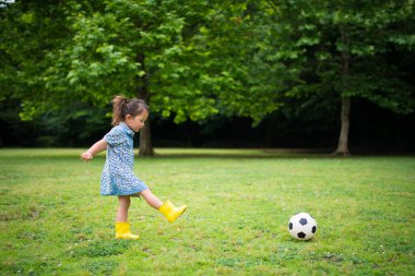 Kız futbol topuyla oynuyor.