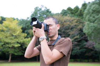 Adam kamera önünde fotoğraf çekiyor. 