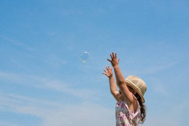 Gökyüzünde sabun köpüğü olan kız 