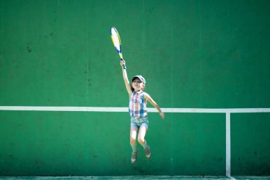 Kortta tenis raketi olan bir kız.