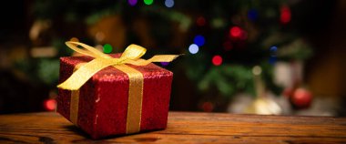 Noel ağacının önüne yerleştirilmiş Noel hediyesi