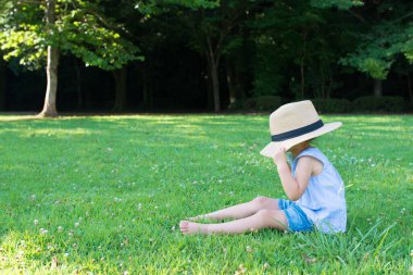 Çok büyük bir şapka takan kız. 