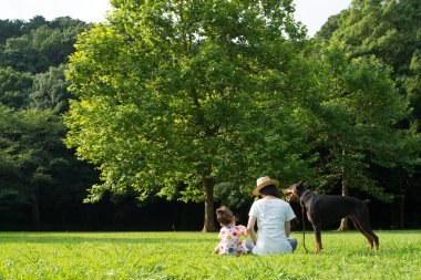 Doberman, anne ve kız çimlerde