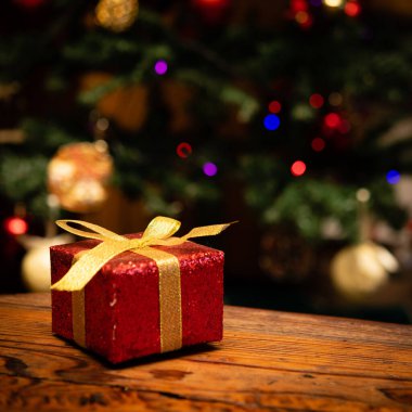 Noel ağacının önüne yerleştirilmiş Noel hediyesi