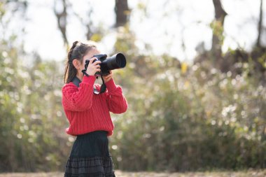 Tek lensli refleks kamerayla fotoğraf çeken bir kız.