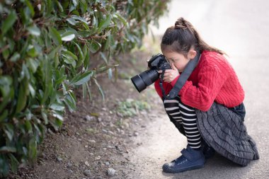 Tek lensli refleks kamerayla fotoğraf çeken bir kız.