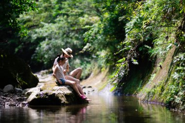 Anne ve kızı dağ deresinde oynuyorlar.