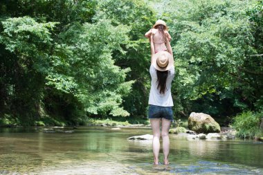 Anne ve kızı nehirde oynuyorlar. 