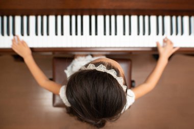 Piyano çalan sevimli Asyalı küçük kız.