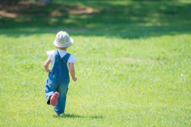 Çimlerde oynayan kız.