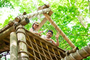 Baba ve kızı orman parkında oynuyor.