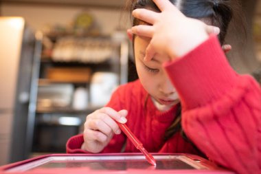 Kız evde ders çalışıyor ve düşünüyor.