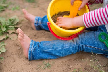 Çocuk sepetle yalınayak oynuyor
