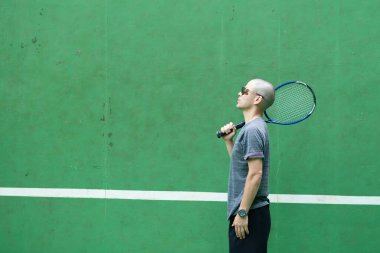 Tenis raketli havalı adam.