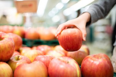 Süpermarkette elma tutan bir çocuğun eli
