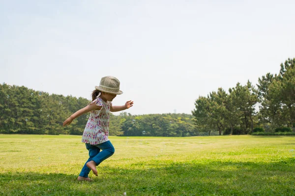 Küçük kız parkta koşuyor.