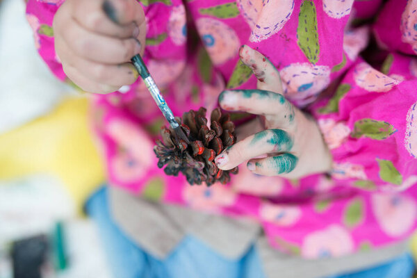 Child paint color to the pine cone