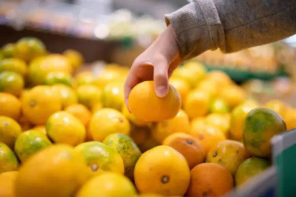 Children\'s hands choosing oranges in the supermarket