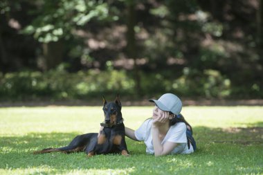 Kadın ağacın altında Doberman 'la rahatlıyor.