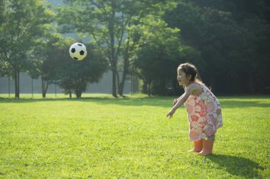 Parkta top oynayan Asyalı kız. 