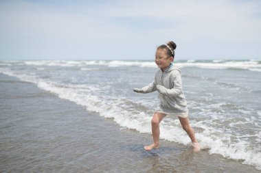 Denizde koşan küçük çocuk