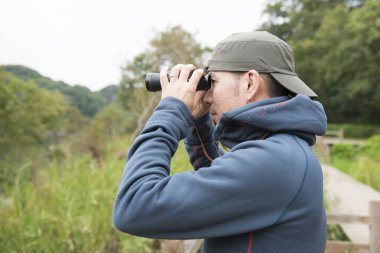 İnsan doğada dürbünle bakar.